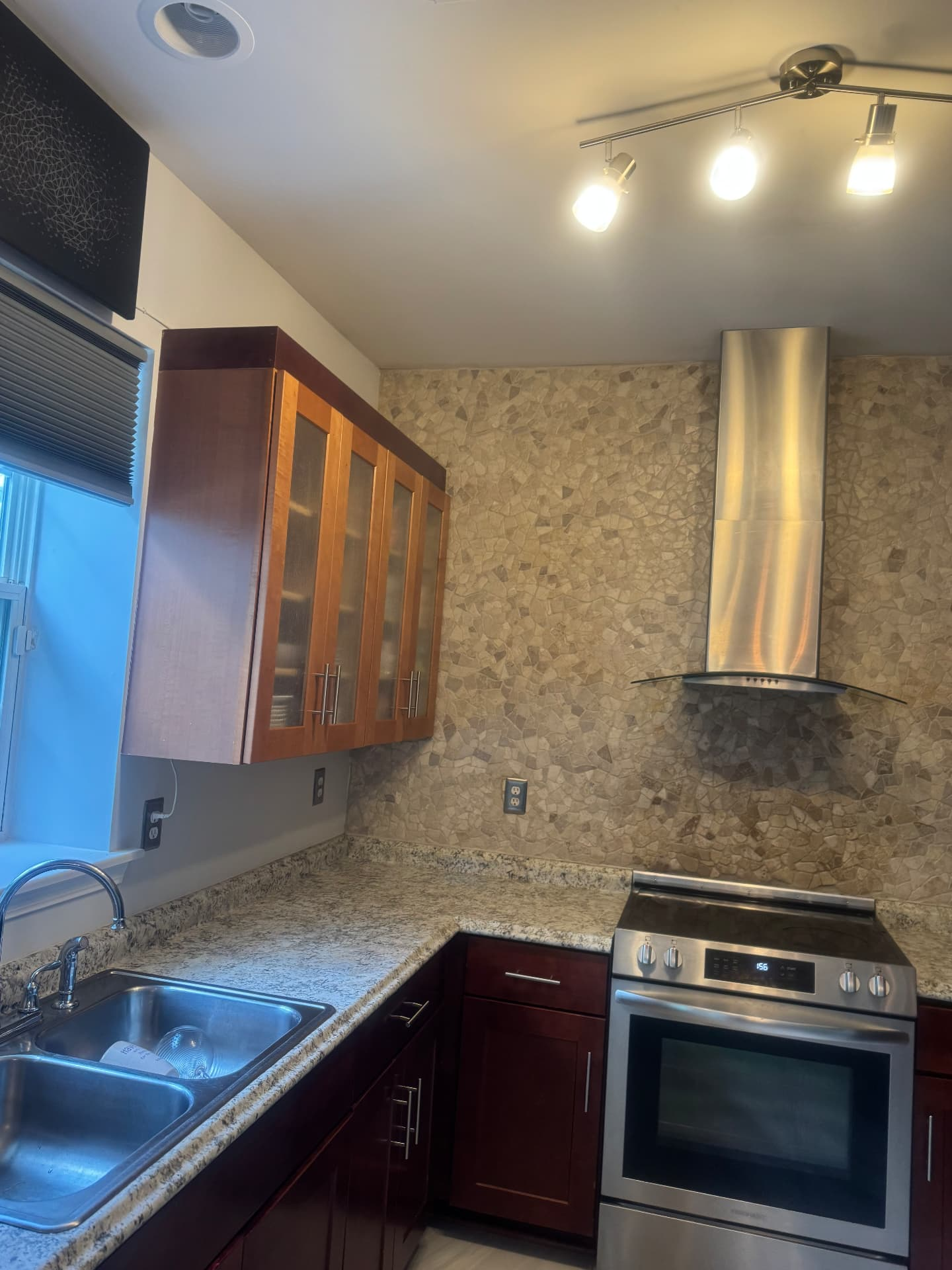 Kitchen after renovation with cherry cabinets, granite counters and stone backsplash