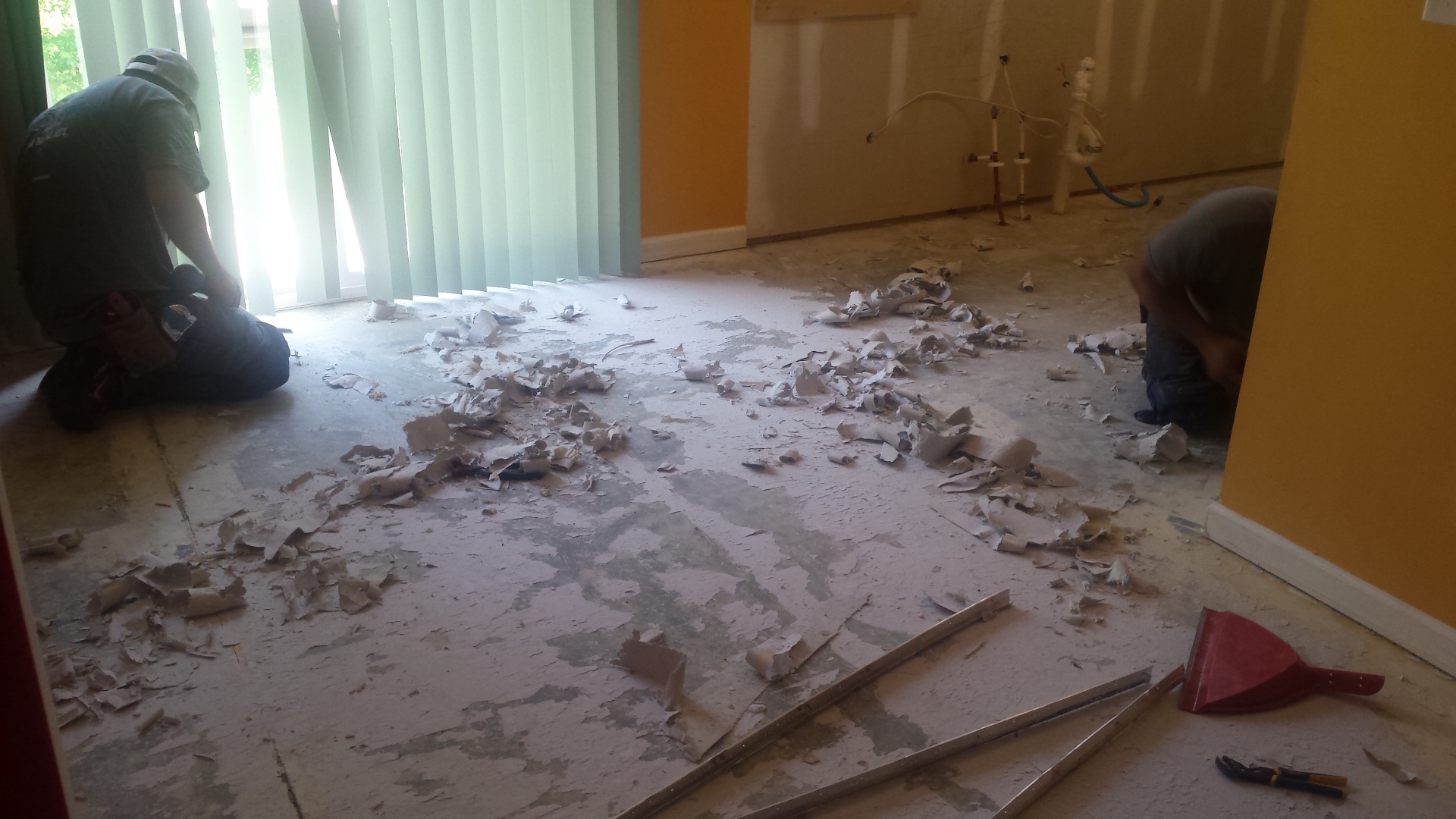 Flooring before replacement with old adhesive scraped from bare subfloor and orange walls